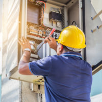 Electrician screwing equipment repairing in fuse circuit breaker box